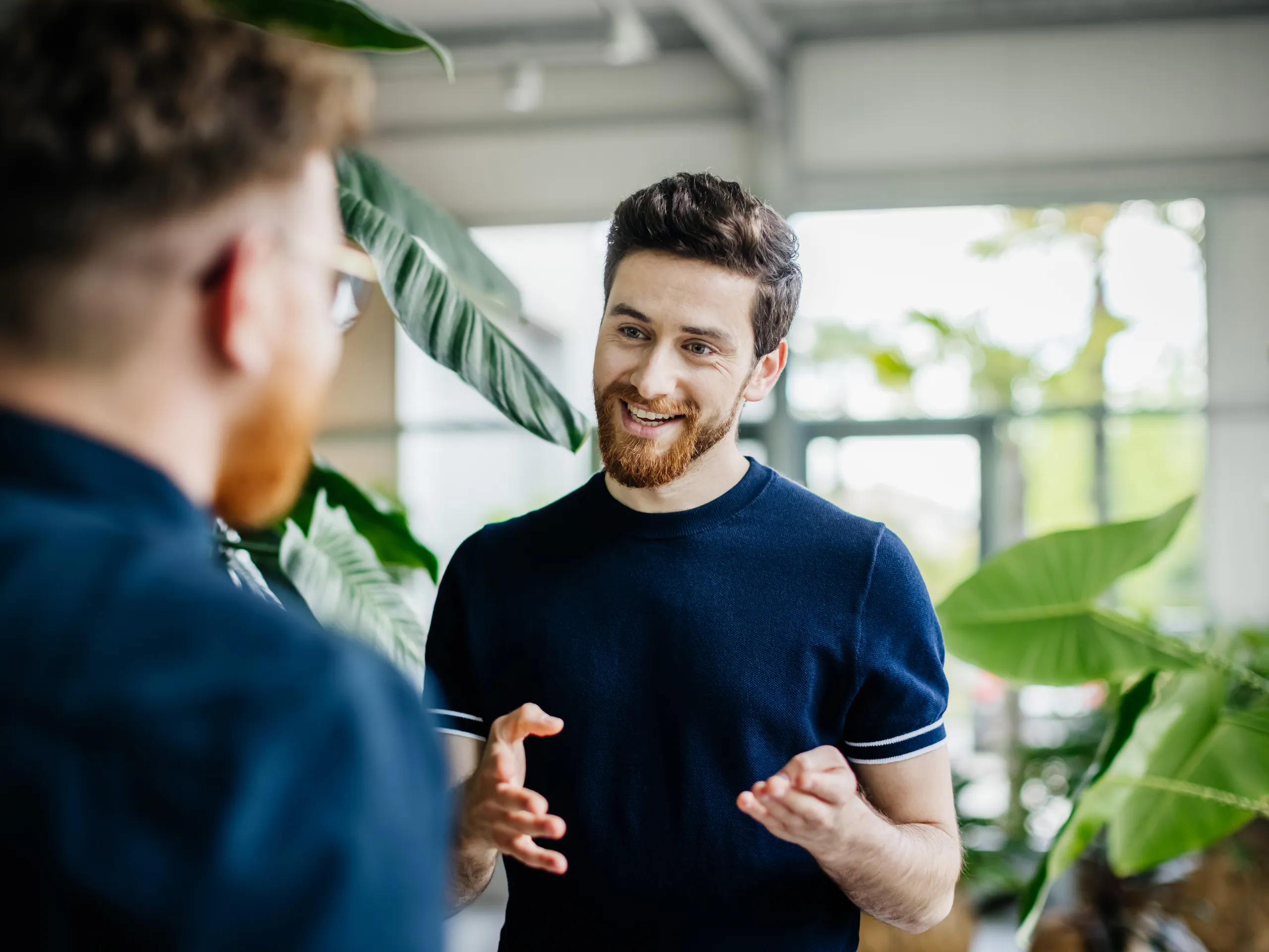 Mann im Gespräch mit einer anderen Person in einem modernen Büro